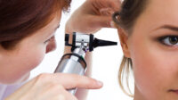 Otolaryngology specialist looking in patient's ear