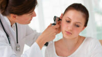 otolaryngology specialist looking in at patient's ear