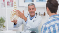 doctor showing his patient a spine model