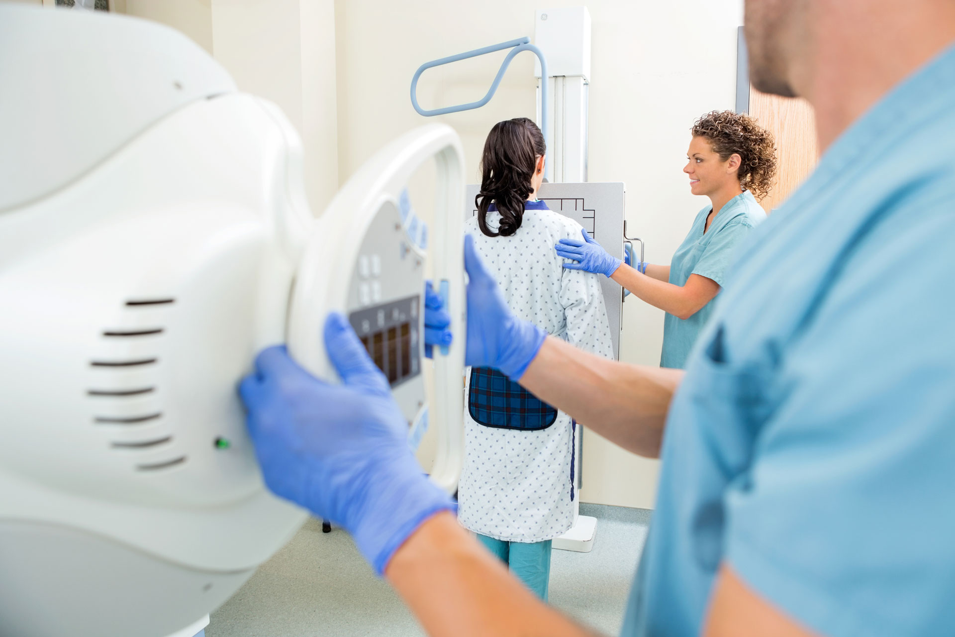 rad tech adjusting xray machine in exam room