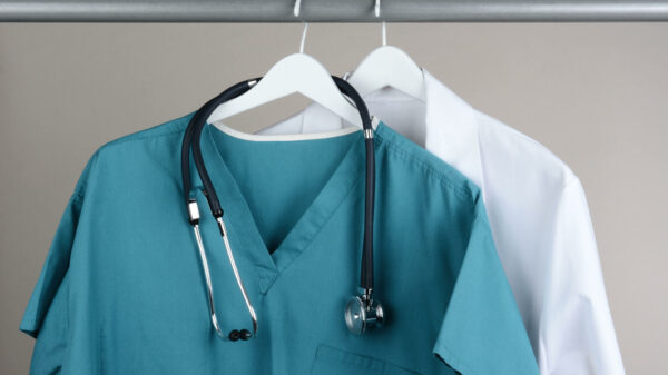 green Scrubs with Stethoscope and Lab Coat on Hanger