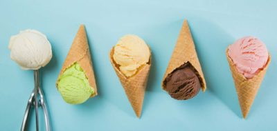 Selection of colorful ice cream scoops on blue background.