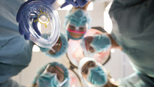 team of surgeons putting anesthesia mask on patient